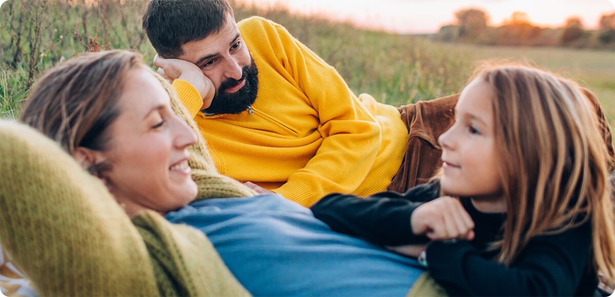 family smiling together in a field