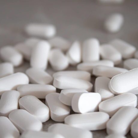 White Zoloft tablets sitting on a white table