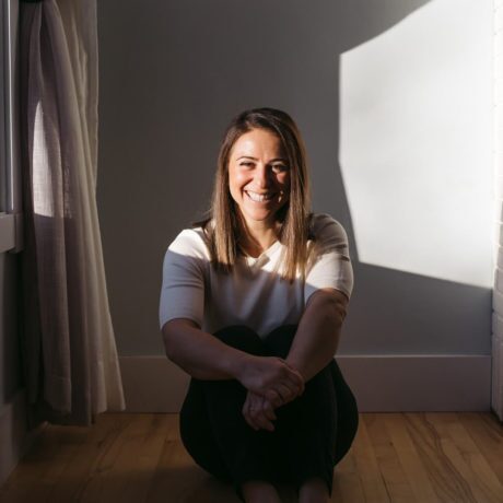 Woman sitting on the floor in the corner of the room