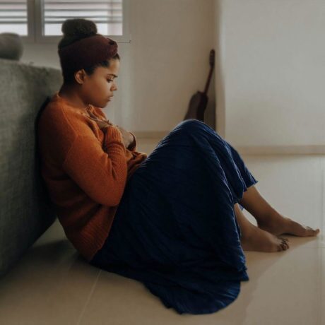 woman having a panic attack on the floor