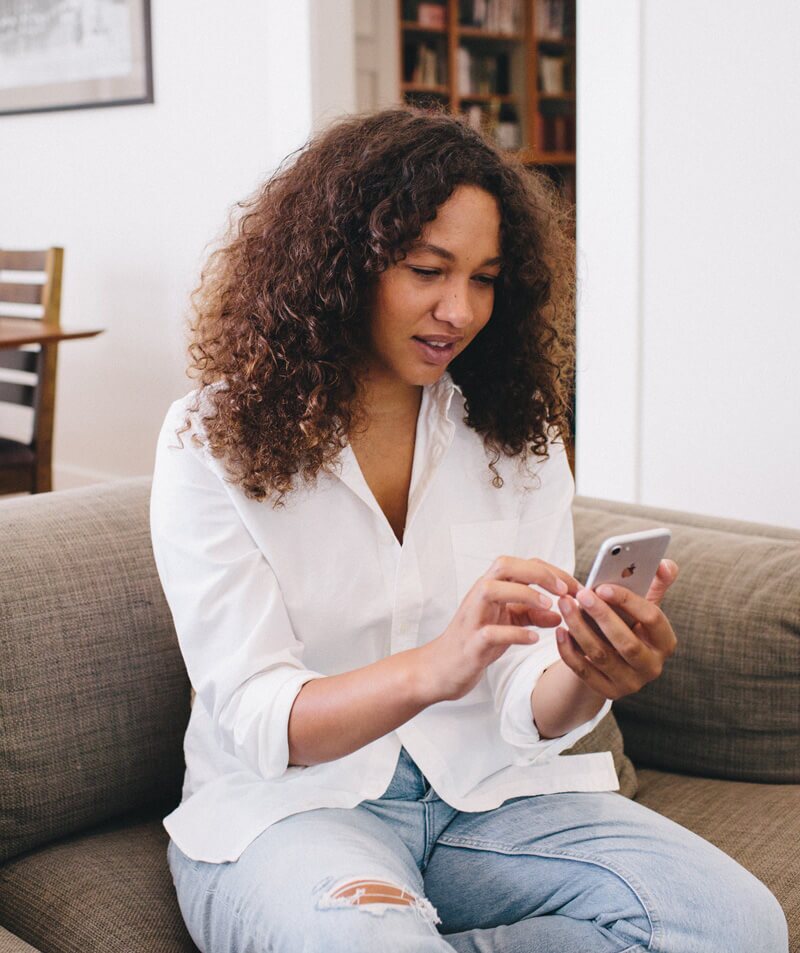 Woman sitting on a couch and looking at her phone