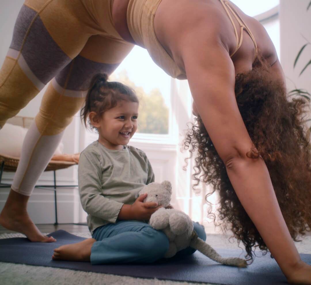 Woman exercising with her smiling child