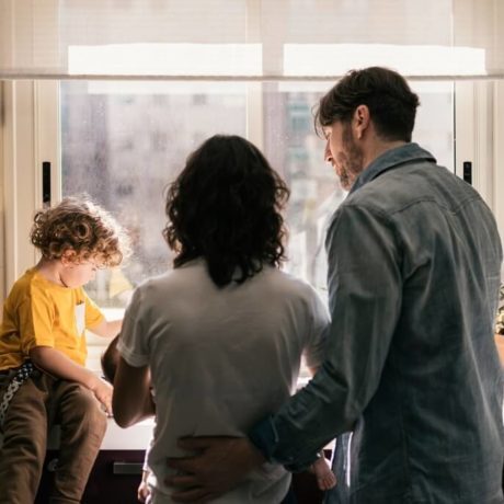 mother and father playing with child in kitchen
