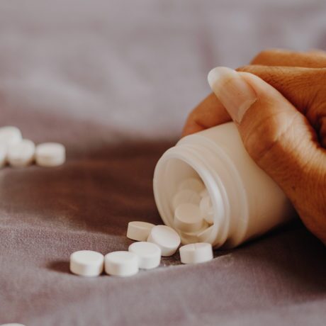 close up of a hand holding a bottle of prescription pills